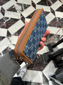 Portefeuille zippé monogrammé en denim bleu et cuir camel