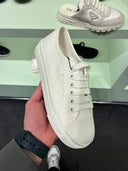 Sneakers basses en drill blanc cassé à logo triangle ton sur ton