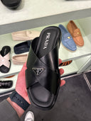 Mules croisées en cuir noir avec plaque triangulaire