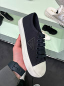 Sneakers basses en drill noir et blanc à logo triangle ton sur ton