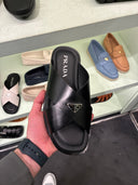 Mules croisées en cuir noir avec plaque triangulaire