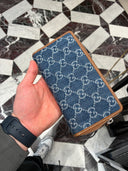 Portefeuille zippé monogrammé en denim bleu et cuir camel