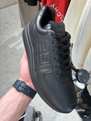 Sneakers épaisses en cuir noir avec monogramme embossé