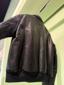 Blouson en cuir noir à col chemise avec logo triangulaire ton sur ton